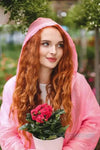 a woman in a pink dress holding a pink flower 